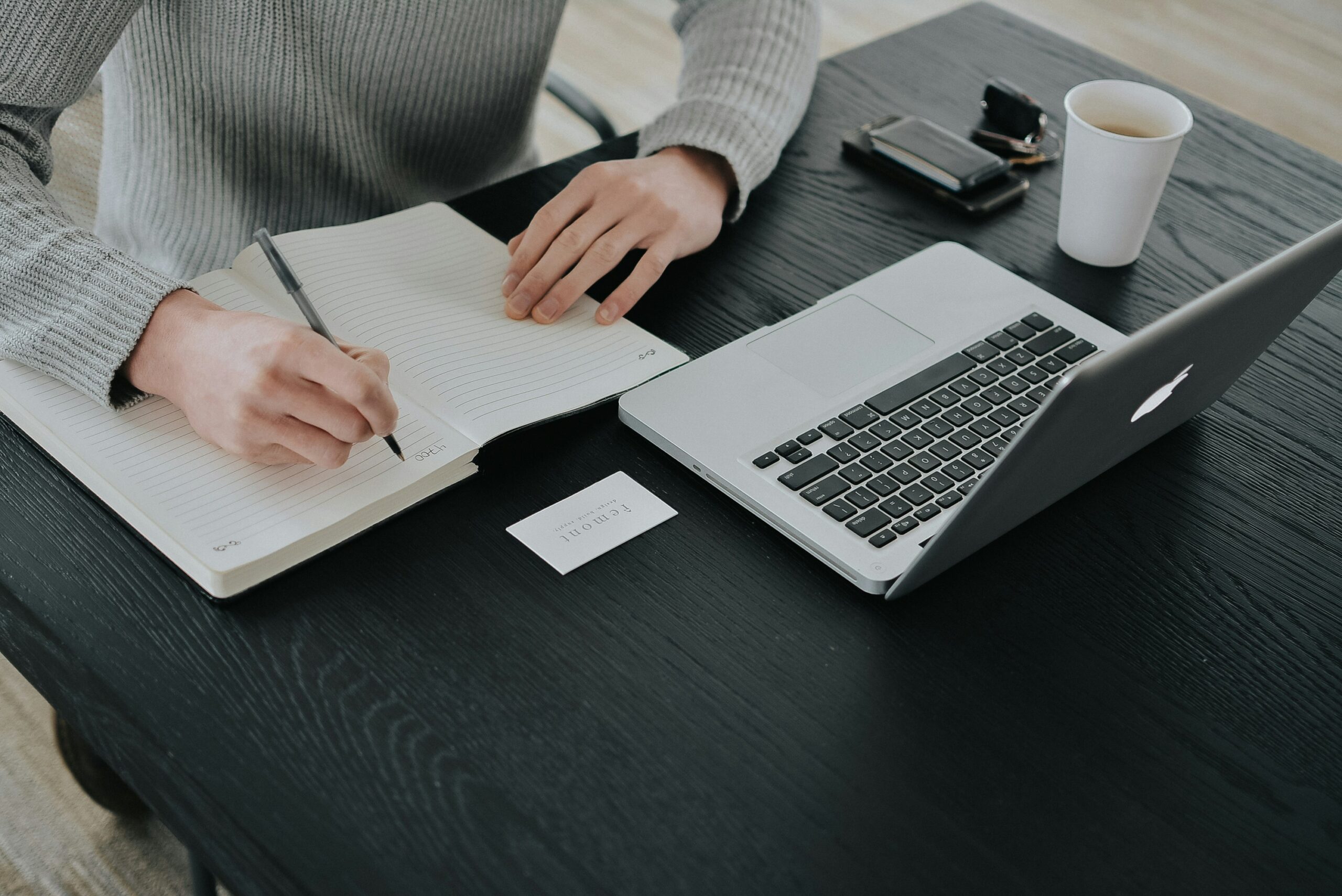 A woman sitting at a laptop, working while reviewing dividend stocks, illustrating passive income with dividend stocks strategy.